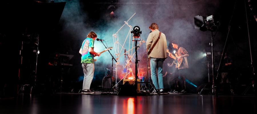 people playing guitars in colored smoke